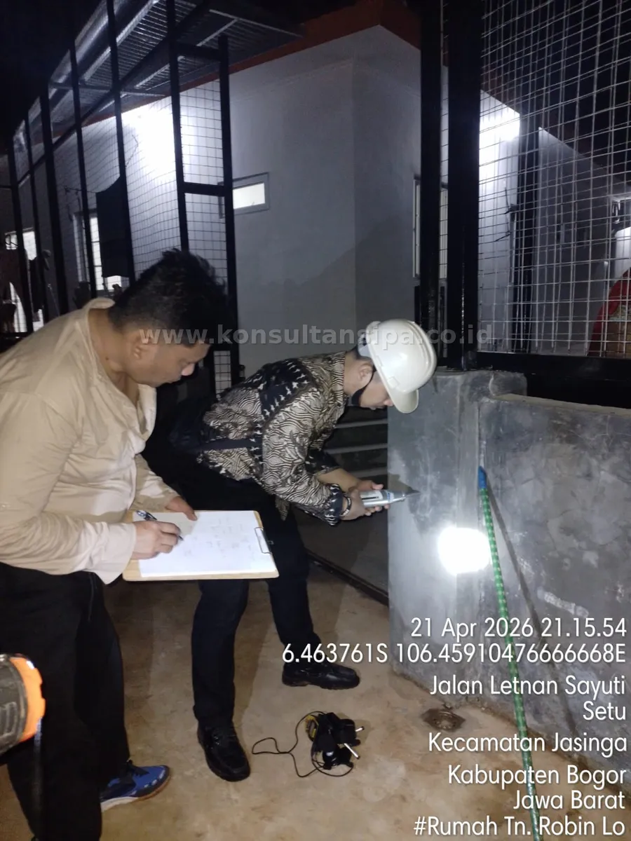 Tim teknisi melakukan hammer test pada dinding beton rumah tinggal sambil mencatat hasil pengujian untuk dokumen SLF di Bogor