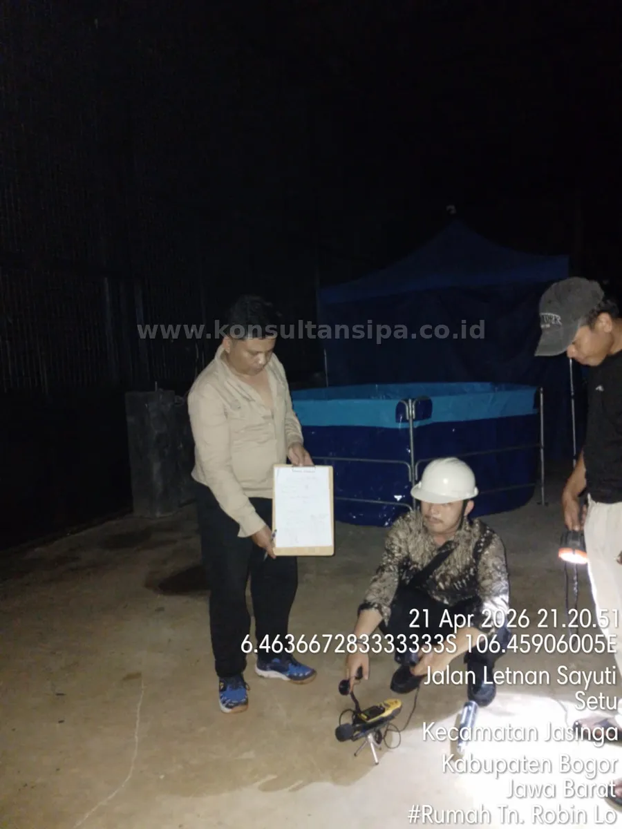 Tim survey melakukan pemeriksaan area eksterior rumah tinggal pada malam hari untuk pengurusan SLF